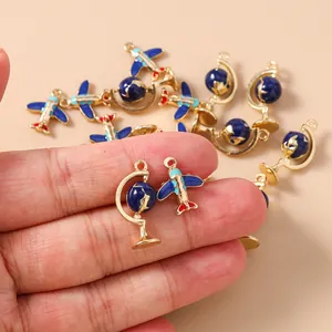 Macro shot of blue enamel airplane and globe charms for DIY jewelry crafting
