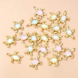 Detailed view of golden sea turtle charms with cat eye opal stones for DIY jewelry making