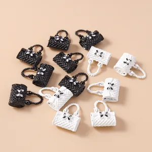 Macro shot of quilted handbag pendants with white bow detail for DIY jewelry making