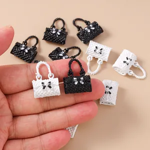Close-up of mini resin handbag charms with quilted texture and bow detail for DIY crafts