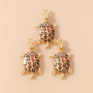 Macro shot of three golden sea turtle charms with leopard print enamel for DIY jewelry making