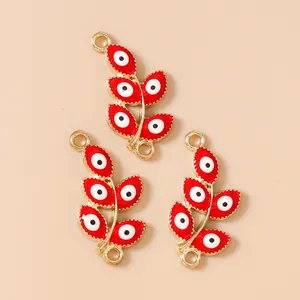 Macro view of red enamel evil eye leaf charms with gold plating and double connectors
