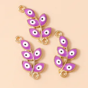Macro view of purple enamel evil eye leaf pendants with dual rings for jewelry making