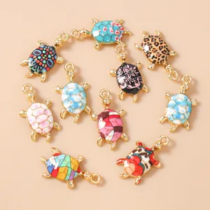 Detail of 10 assorted turtle pendants with colorful patterns and golden metal alloy finish