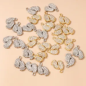 Macro detail of rhinestone-pave infant footprint charms in gold and silver finish