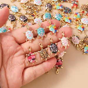 Close-up of colorful enamel turtle pendants with floral and leopard patterns for DIY jewelry
