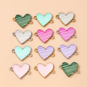 Dettaglio di connettori a cuore in smalto colorato a righe per creazione gioielli fai-da-te