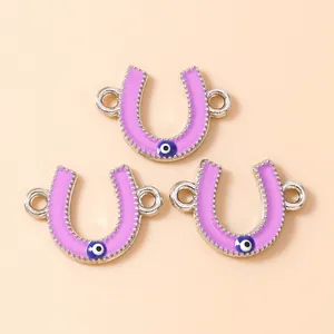 Three horseshoe charms with purple enamel and blue evil eye detail for jewelry making