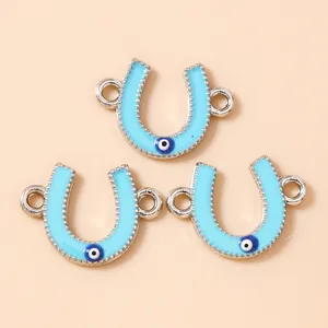 Macro detail of blue horseshoe evil eye pendants with double connectors and enamel finish