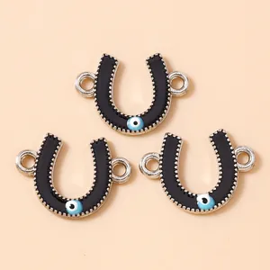 Detailed macro view of black enamel horseshoe pendants with blue evil eye charms