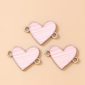 Dettaglio di ciondoli a cuore a righe rosa con doppi anelli per la creazione di gioielli
