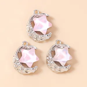 Close-up of alloy moon and star pendants with lava texture and pink cat-eye stars