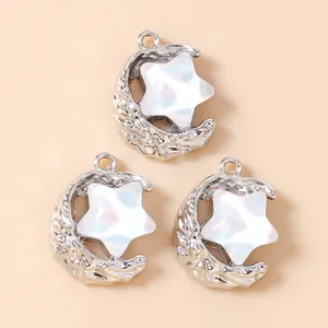 Detail of silver crescent moon charms with iridescent star inlay for DIY jewelry