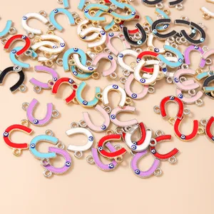 Macro shot of colorful enamel horseshoe Evil Eye charms with dual connector rings for DIY jewelry