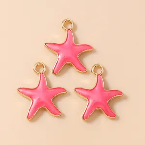Close-up of three pink and gold starfish pendants for DIY jewelry making