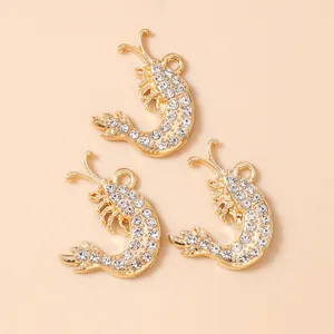 Three golden lobster charms with sparkling white crystals for DIY jewelry projects