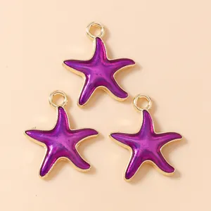Macro detail of three purple starfish pendants with golden alloy frames for DIY jewelry