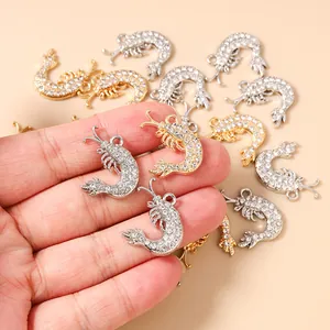 Macro detail of hand-held lobster pendants with sparkling rhinestones for DIY jewelry
