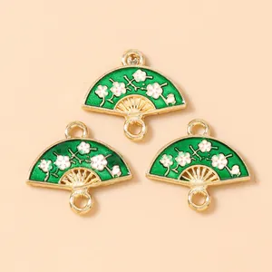 Detail of green floral fan charms with gold edges and white plum blossom patterns