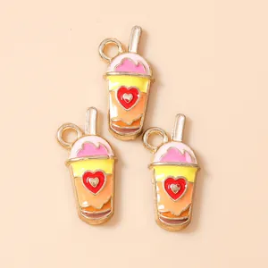 Détail de trois pendentifs thé au lait en alliage coréen avec émail et motifs de cœur