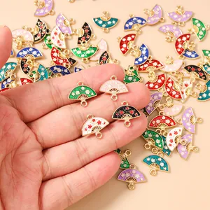 Macro detail of hand-held enamel flower fan pendants for DIY necklace making