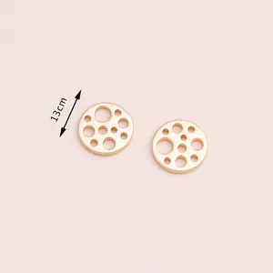 Detail of 13cm hollow geometric gold alloy pendants showing intricate circular cutouts