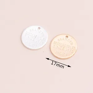 Detailed view of 17mm gold and silver round metal charms with vintage style engraving