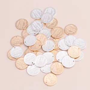Macro shot of vintage round metal charms with engraved letters in gold and silver finish
