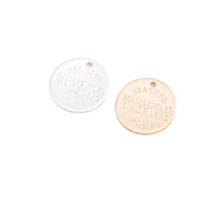 Macro shot of silver and rose gold round metal pendants with retro engraved lettering
