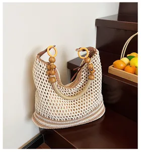 Close-up of woven beach bag featuring natural mesh texture and large wooden bead handles