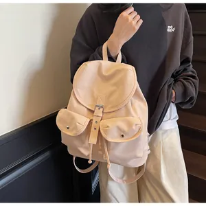 Vue détaillée du sac à dos en nylon abricot avec boucles en cuir et poches frontales