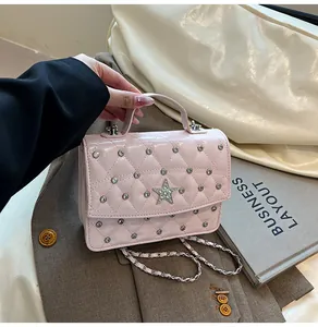 Détail du sac à main en cuir verni rose avec motif matelassé et cristaux brillants