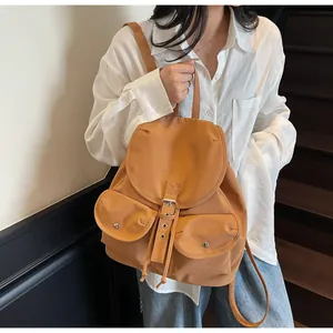 Détail d'un sac à dos vintage camel avec deux poches avant et fermeture à boucle