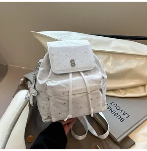 Detailansicht eines weißen Rucksacks mit Sternmuster, Silberbeschlägen und Sternanhänger
