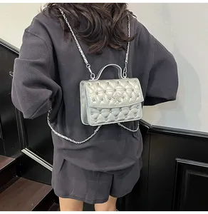 Détail du sac argenté matelassé avec étoiles en strass et bandoulière en chaîne