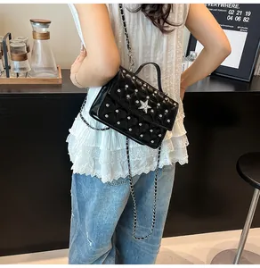 Détail d'un mini sac matelassé noir avec boucle en diamant en forme d'étoile et chaîne