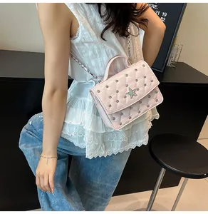 Détail du mini sac matelassé rose avec logo étoile en cristal et rivets argentés