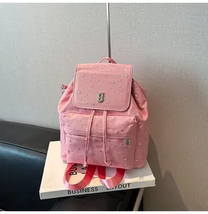 Detail des rosa Canvas-Rucksacks mit silbernen Sternen und einem Logo aus Metall