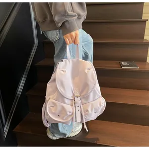 Détail d'un sac à dos en nylon violet clair avec rabat et deux poches sur l'escalier