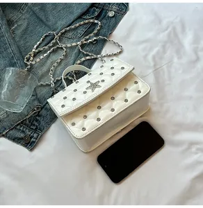 Détail du sac à bandoulière blanc matelassé avec clous argentés et boucle étoile