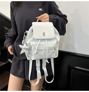 Detail des weißen Rucksacks mit Sternmuster, Kordelzug und Silberstern-Anhänger