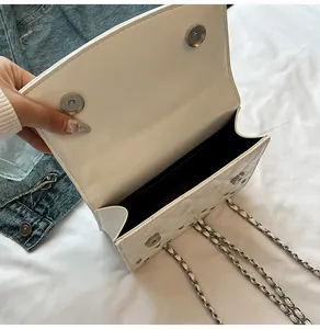 Détail du sac matelassé en similicuir blanc avec fermoirs magnétiques argentés