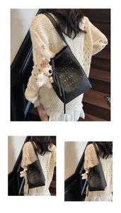 Detail view of black hollow-out bucket bag with fringe and white bear plush charm
