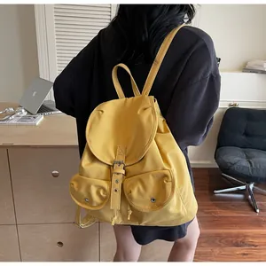 Détails arrière d'un sac à dos en toile jaune avec doubles poches et boucles métalliques