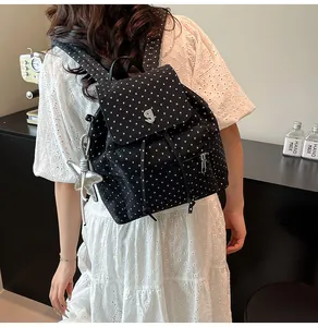 Detailansicht eines schwarzen Rucksacks mit Sternenmuster und Metallschnalle mit g-Logo