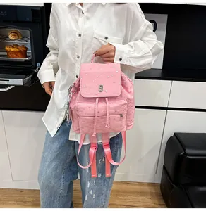 Detail eines rosa gepunkteten Rucksacks mit silbernen Sternen und Bärchen-Anhänger