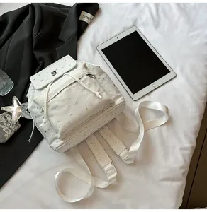 Detail eines weißen Sternenrucksacks mit Kordelzugverschluss und Metallschnalle