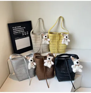Detailed view of laser-cut bucket bags in five colors with cute bear plush charms