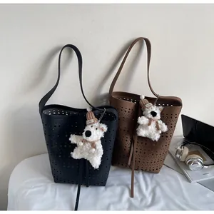 Detail of laser-cut hollow pattern on black and brown faux leather tote bags
