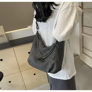 Detailed close-up of a large grey textured tote bag with silver chain and metal buckle